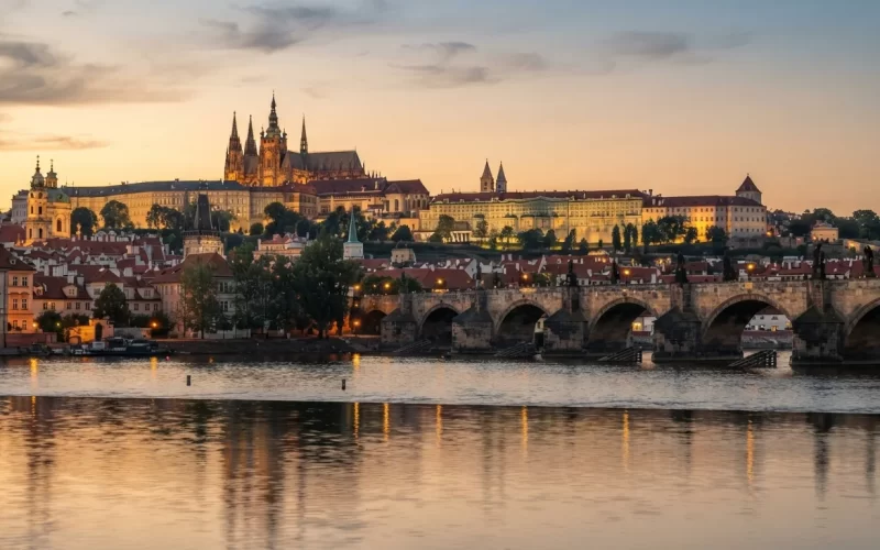 Karlův most a Pražský hrad nad Vltavou při západu slunce
