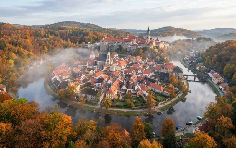 Historické město s hradem nad meandrem řeky v podzimních barvách