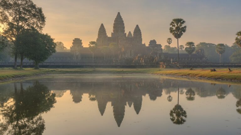 Věže chrámu Angkor nad korunami stromů za ranního oparu