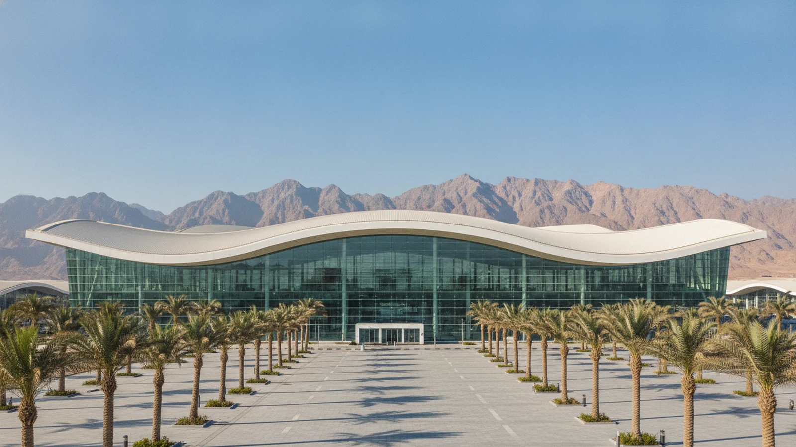 Moderní terminál letiště Hurghada s palmami a horami u Rudého moře