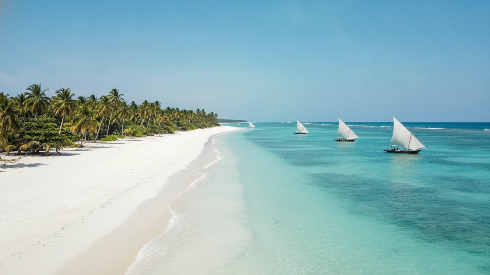 Bílá pláž s tyrkysovým mořem a dřevěnými loďkami na severu Zanzibaru