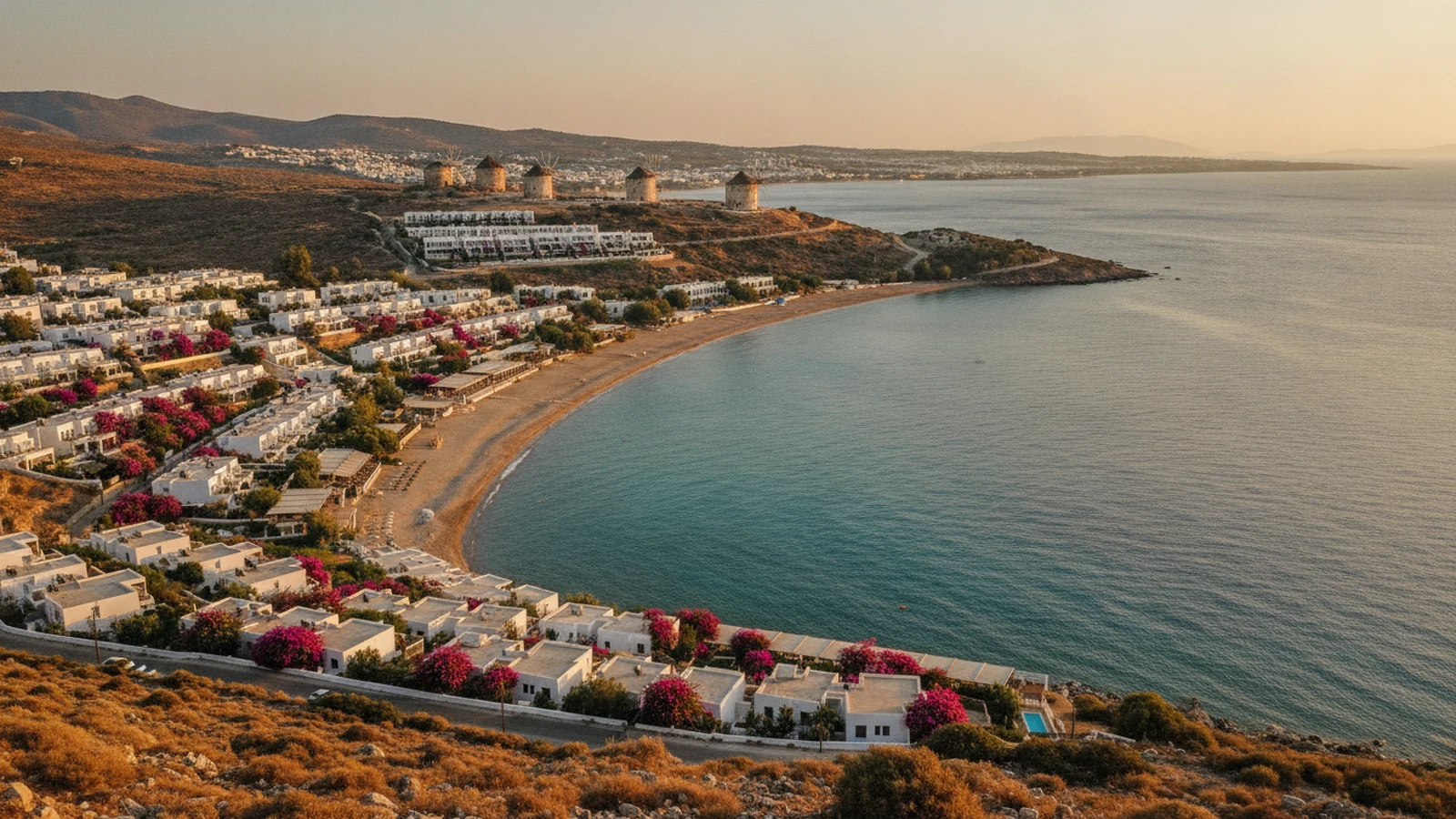 Zátoka Gümbet na poloostrově Bodrum s bílými hotely na svahu a větrnými mlýny na hřebeni
