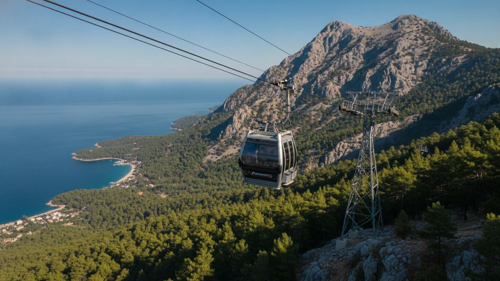 Kabina lanovky Olympos Teleferik nad borovými lesy s výhledem na pobřeží u Kemeru