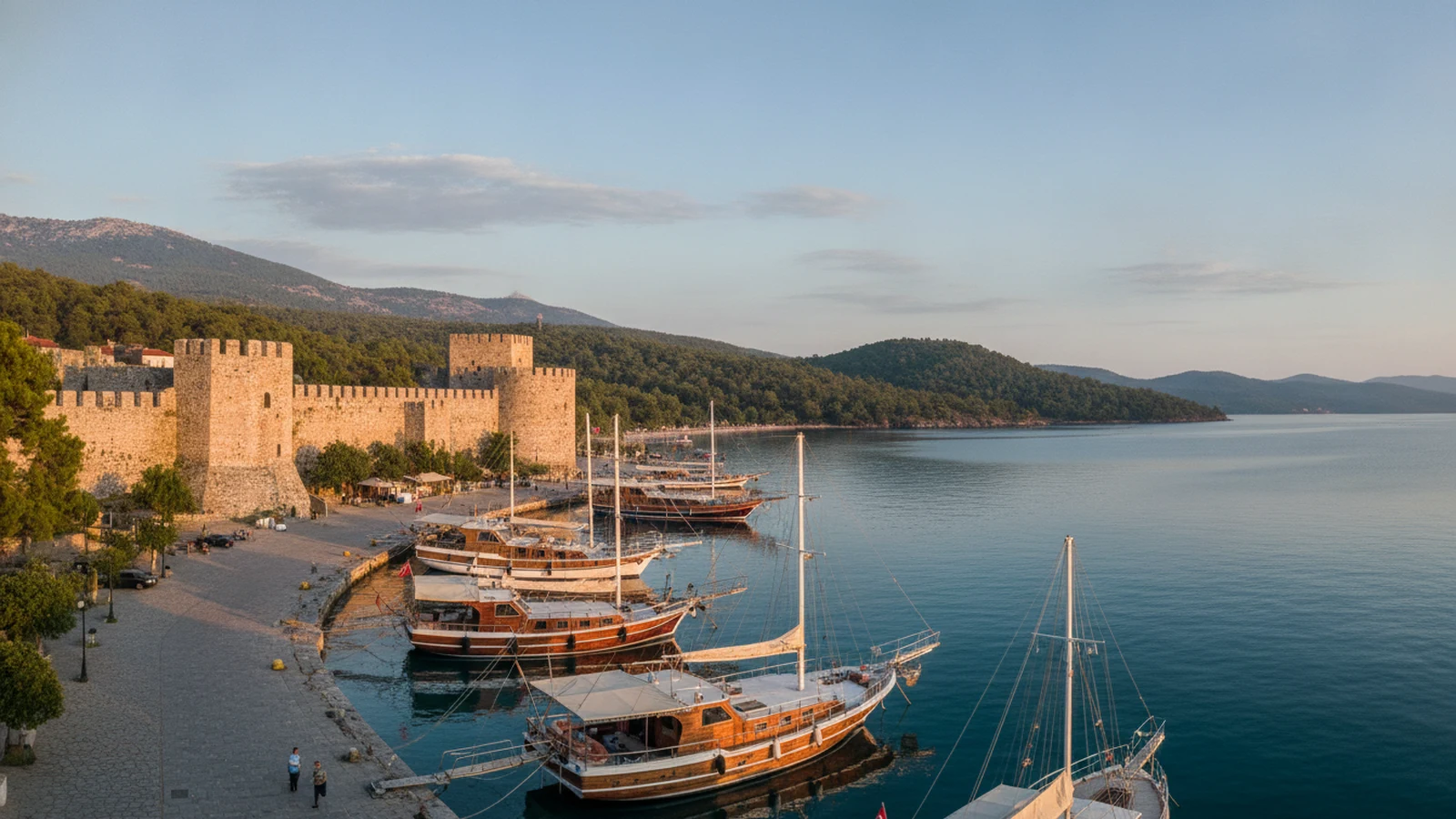 Kamenný hrad Marmaris nad přístavem starého města a borové kopce kolem zátoky