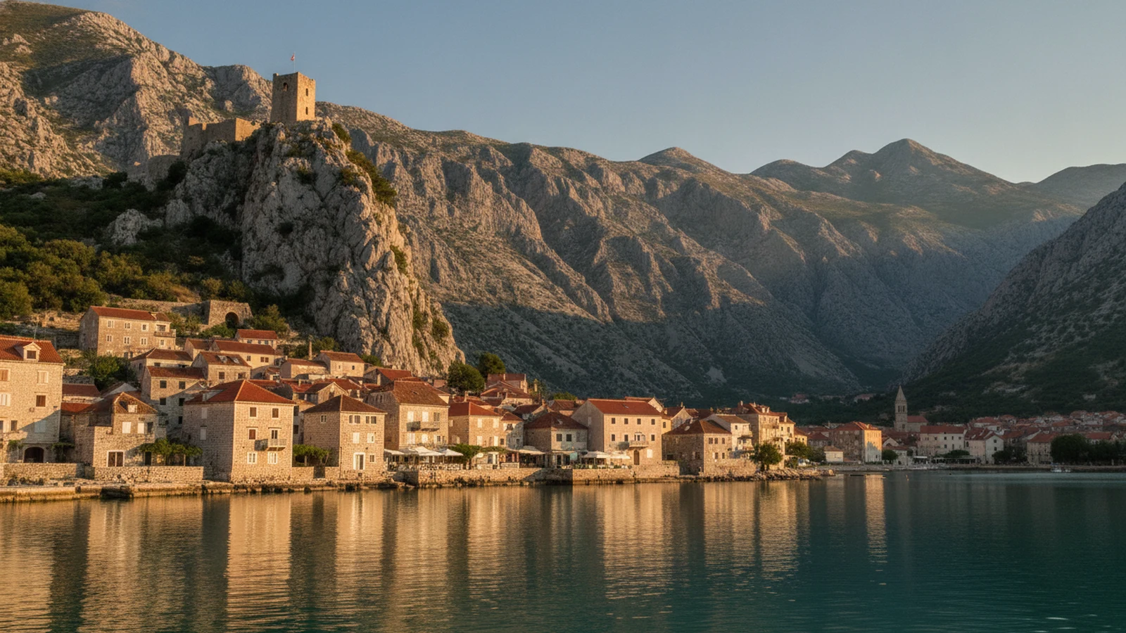 Staré město Omiš u ústí Cetiny s pevností Mirabela na skále a horami kaňonu