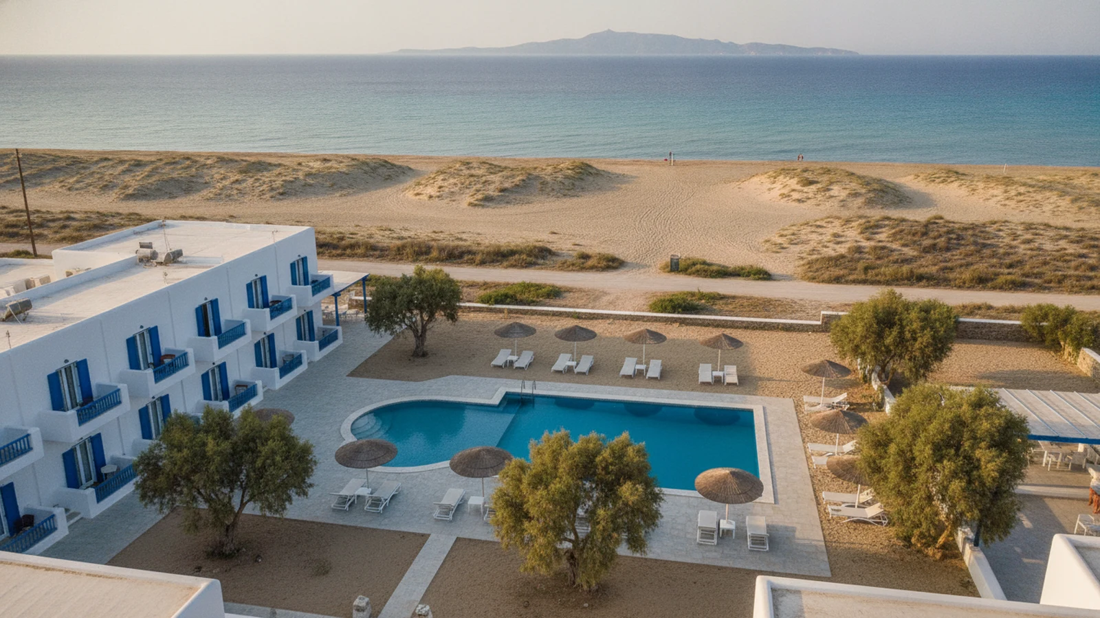 Bílý kykladský hotel s bazénem u písečné pláže Plaka na západním pobřeží Naxu